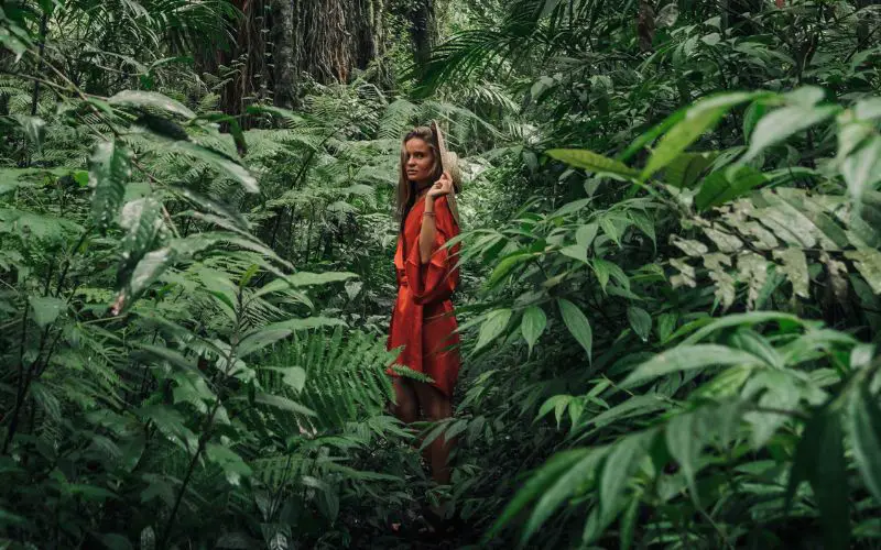 Photo showing a woman in red dress in the middle of a forest