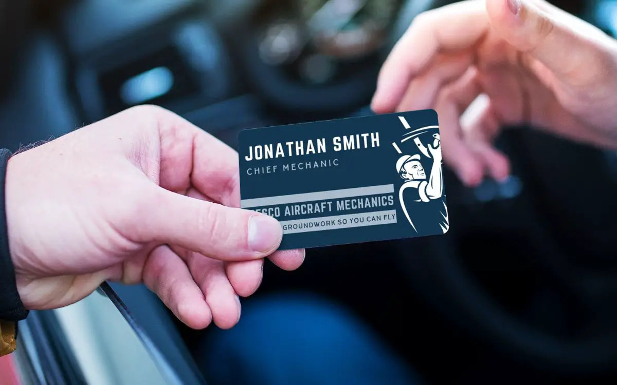 Photo showing a hand holding a business card with the name Jonathan Smith on it and another hand about to receive the card