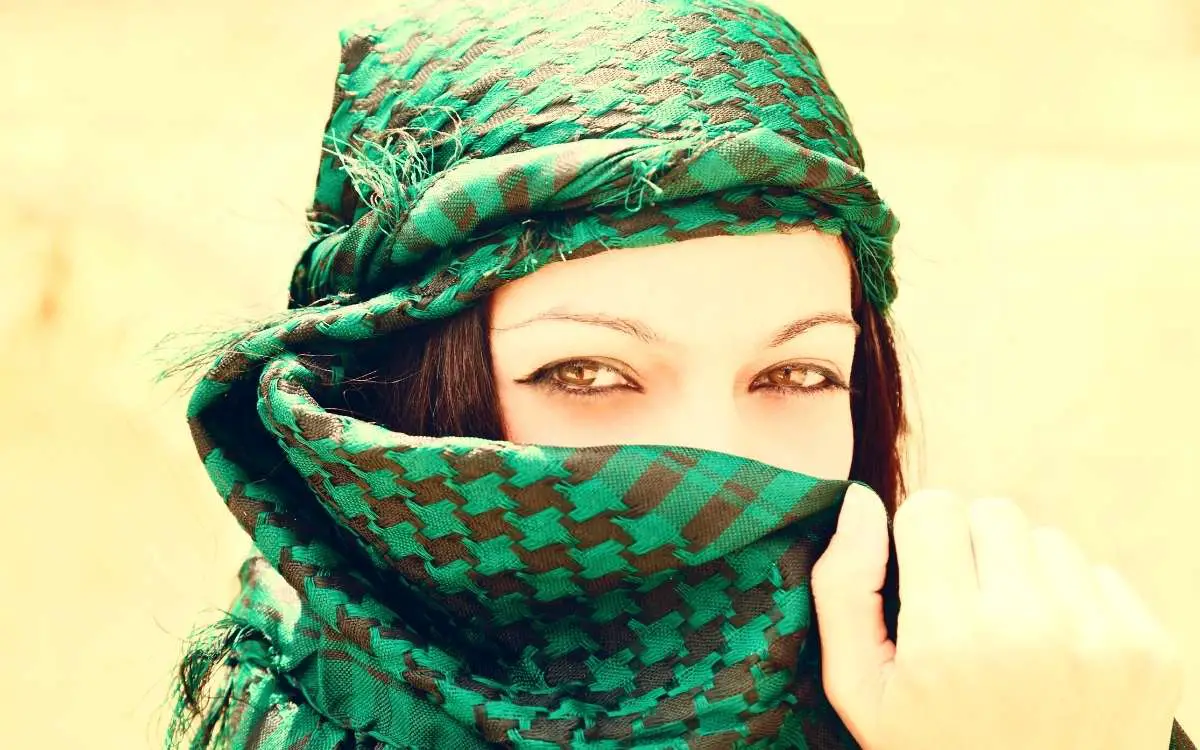 Woman is wearing green head cover that also covers the face and seems like she have what you call Levant DNA